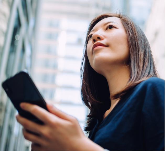 Asian female with cell phone, looking off into the distance